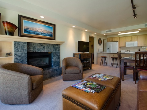 Unwind in your open-concept living space, where a cozy fireplace, comfortable seating, and a fully-equipped kitchen create the perfect home base for mountain adventures.