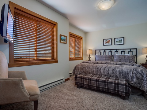Unwind in your peaceful bedroom featuring warm wood accents, plush bedding, and cozy seating—your perfect retreat after a day of mountain adventures.