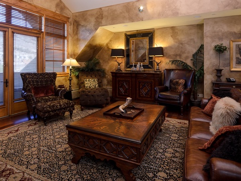 Step into your elegant living room where rich leather seating, textured walls, and warm lighting create a sophisticated mountain retreat feel. Curl up by the fireplace with your favorite book.