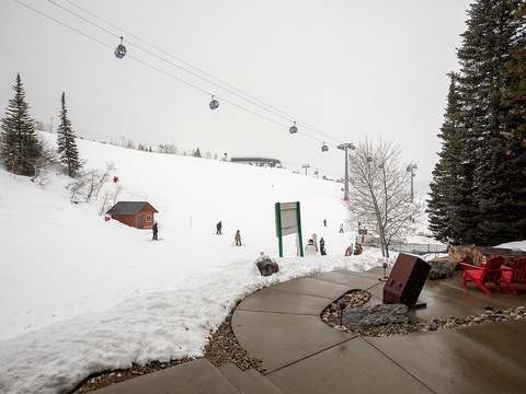 Direct access to the ski slopes, with a gondola system overhead and snowy runs leading right from the property's patio area.