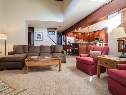Sink into the plush sectional and enjoy your open-concept retreat, where the inviting living space flows into a fully equipped kitchen—perfect for relaxing or cooking together.