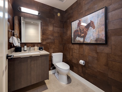 Step into your private bathroom with warm wood-textured walls and modern fixtures. A sleek vanity and well-lit mirror create a welcoming space to refresh after a day of adventure.