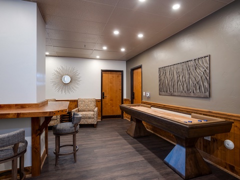 Your private game room awaits, featuring a full-sized shuffleboard table for friendly competition and a cozy seating nook—perfect for unwinding after a day of adventure.