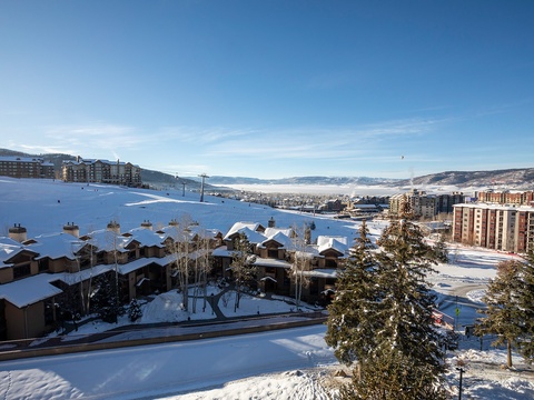 A stunning winter resort panorama with snow-covered slopes, evergreen trees, and surrounding mountain ranges—captured as part of the property's scenic location.