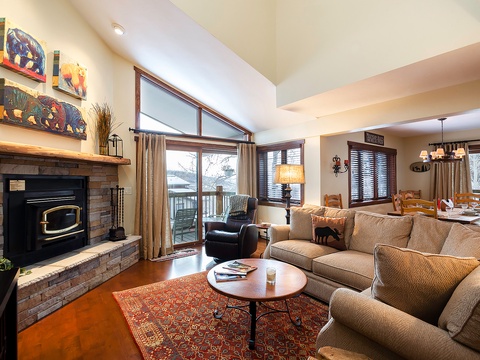 Sink into plush sofas by the cozy fireplace, where vaulted ceilings and abundant natural light create your perfect mountain retreat for relaxing evenings.