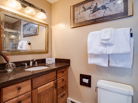 Freshen up in your well-appointed bathroom, featuring a granite vanity, fluffy towels, and thoughtful artwork that adds character to your space.