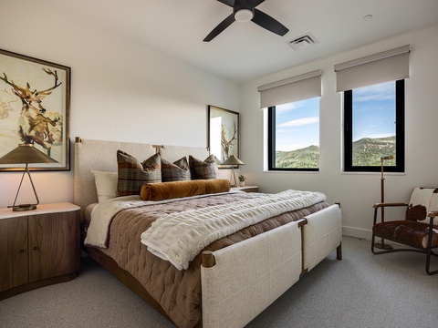 Sink into this cozy bedroom where mountain views greet you each morning through oversized windows, and rustic art adds warmth to your peaceful retreat.