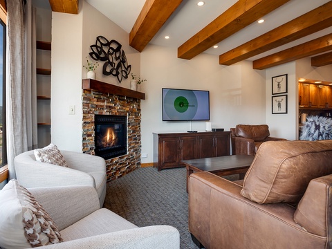 Sink into rich leather sofas near the warmth of your brick fireplace. Exposed beams overhead add rustic charm while a smart TV awaits your favorite shows.