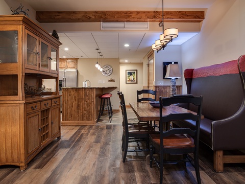 Your open-concept living and dining area invites you to relax with warm wood details, stylish furnishings, and a fully equipped kitchen just steps away, perfect for gathering and unwinding.