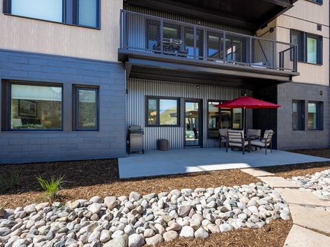 This modern property offers a spacious patio complete with outdoor dining and a BBQ grill, perfect for enjoying meals in the fresh air while taking in the surrounding scenery.