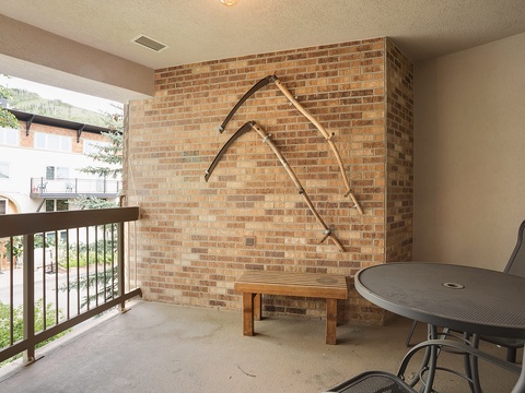 Your private balcony offers a peaceful retreat with seating and a unique mountain-inspired accent wall—perfect for morning coffee or evening relaxation overlooking the greenery.