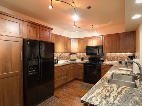 Your spacious kitchen invites culinary adventures with warm wood cabinetry, gleaming granite countertops, and modern appliances ready for your favorite recipes.