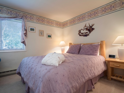Unwind in your cozy bedroom with a plush bed dressed in soft linens, warm bedside lighting, and charming rustic touches that invite restful sleep after a day of adventure.