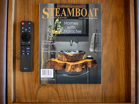 A local magazine and remote rest on the table, offering entertainment and insights about the area during your downtime.
