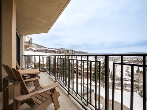 Elevated balcony overlooks snow-dusted mountains and valley below, part of the scenic surrounding area near the property entrance.