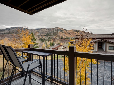 A peaceful mountain setting framed by golden autumn foliage, with rolling hills and neighboring properties creating a serene backdrop to the surrounding area.