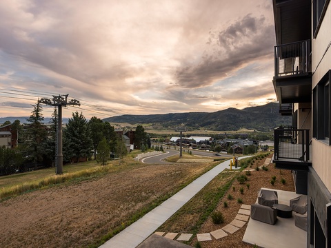 The property is situated in a quiet residential neighborhood with scenic mountain and lake surroundings visible from the building's exterior and grounds.