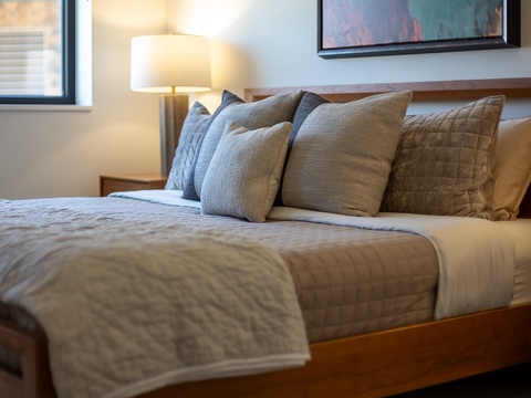 Sink into the plush bedding and let the warm glow of the bedside lamp melt away your day. A peaceful retreat awaits you.