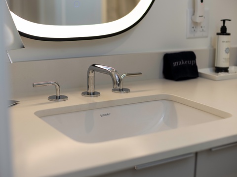 Freshen up at your sleek vanity with modern fixtures and an illuminated mirror, perfectly designed for your morning routine.
