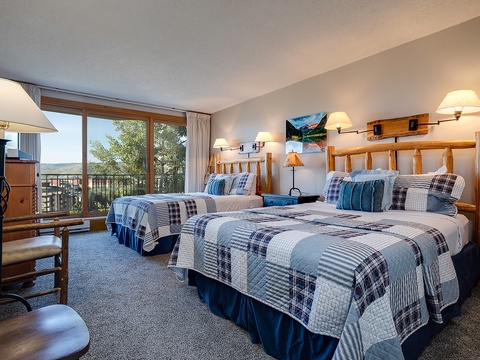 Settle into your cozy alpine retreat with rustic log headboards, plaid quilts, and scenic mountain views through your private balcony—perfect for peaceful mornings and starry evenings.