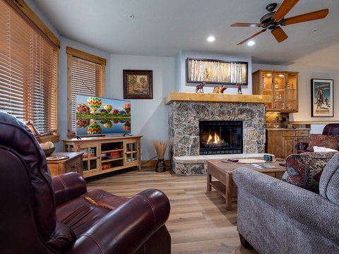 Curl up in this warm, inviting living room where a stone fireplace and plush seating create the perfect retreat for your mountain evenings together.