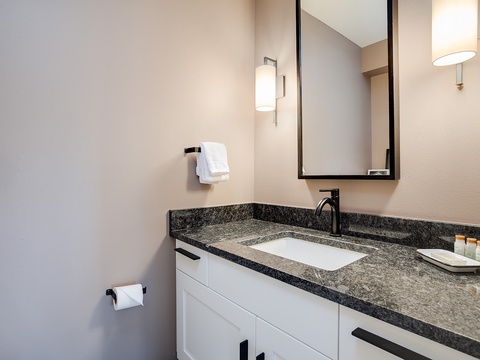 Your private bathroom features a sleek granite vanity, modern fixtures, and ample lighting—perfect for refreshing after a day of exploring.