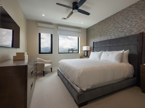 Drift off in your serene bedroom with plush linens and a gentle ceiling fan, while ocean views peek through the windows to greet you each morning.