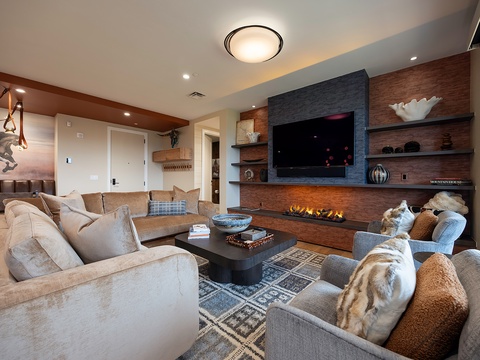 Sink into plush seating and feel the warmth of the glowing fireplace as you unwind in this inviting living room, where modern comfort meets mountain elegance.