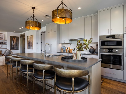 Picture yourself preparing meals in this sleek, modern kitchen where style meets comfort. The spacious island invites you to gather, dine, and create memories under warm ambient lighting.