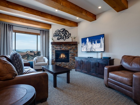 Unwind in your inviting living room where mountain views and a warm fireplace create the perfect retreat. The rustic beamed ceiling and plush seating invite you to relax after a day of adventure.