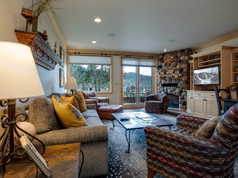 Unwind in your cozy living room, where a stunning stone fireplace and mountain views create the perfect setting for relaxed evenings with loved ones.