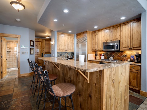 Gather around your granite-topped breakfast bar while the aroma of fresh coffee fills this warm, wood-finished kitchen. The island seating invites lingering conversations as you plan your mountain adventures.
