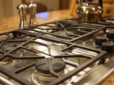 Your fully equipped kitchen features a professional gas stove, perfect for preparing home-cooked meals during your stay, with granite countertops and gleaming cookware ready for use.