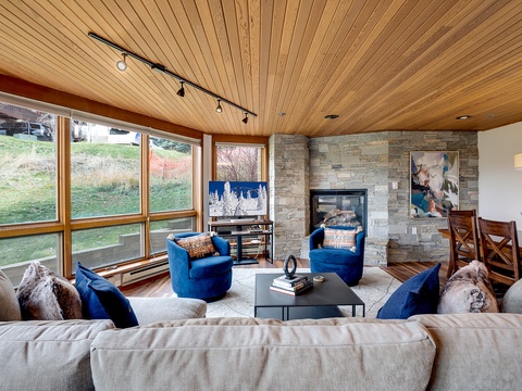 Sink into plush seating, warm up by the fireplace, and gaze through expansive windows framing peaceful natural views—your ideal retreat awaits.