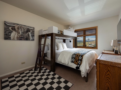 Settle into your cozy bunk room where rustic mountain charm meets modern comfort. Through your window, sweeping mountain views frame your Alpine retreat.