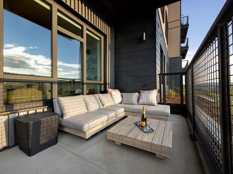 Step onto your private balcony where contemporary comfort meets stunning views. Settle into plush seating with a glass of champagne as the sky unfolds above rolling landscapes—your peaceful retreat awaits.