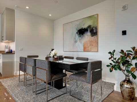 Your elegant dining space awaits, where contemporary design meets comfort. Gather around the sleek table beneath modern artwork and ambient lighting, perfect for memorable meals together.