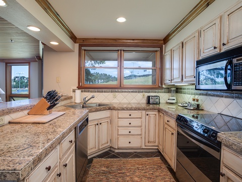 Your fully-equipped kitchen awaits with granite counters, modern appliances, and scenic water views—perfect for preparing meals while soaking in the peaceful surroundings and natural light.