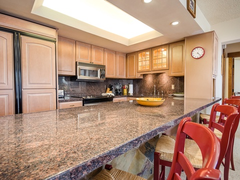 Your well-appointed kitchen features gleaming granite counters, modern appliances, and a sunny skylight overhead—perfect for preparing meals while soaking in natural light and comfort.