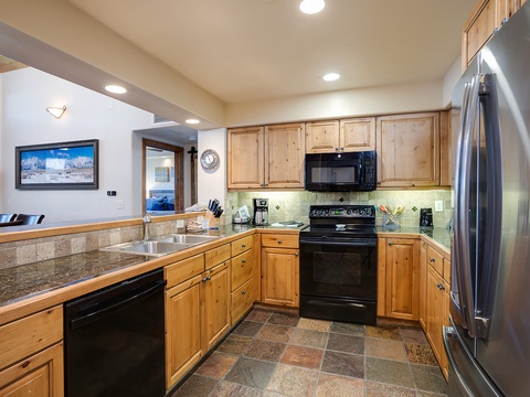 Your full kitchen features modern stainless steel appliances, warm wood cabinetry, and granite counters—perfect for preparing home-cooked meals during your mountain getaway.