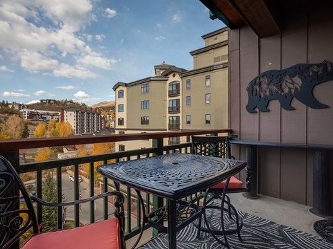 Sip your morning coffee on your private balcony as golden autumn leaves frame mountain views and nearby buildings dot the hillside around you.
