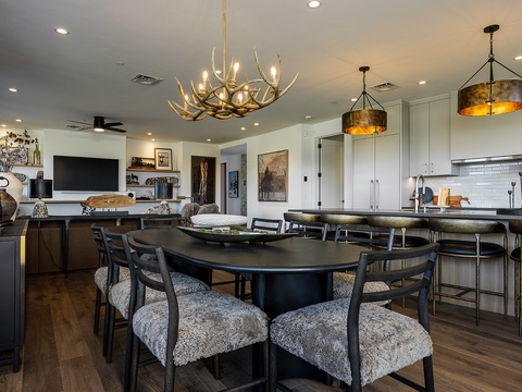 This open-concept space blends dining and living seamlessly, with rustic chandeliers, modern finishes, and a fully-equipped kitchen where you'll love preparing meals together.