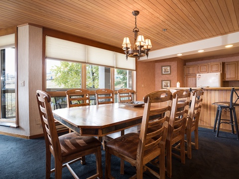 Gather around this spacious dining table for memorable meals together, with natural light pouring in and a cozy kitchen nearby for easy serving.