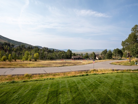A scenic mountain community with forested hillsides, open meadows, and quiet residential streets characterizes the peaceful neighborhood surrounding the property.