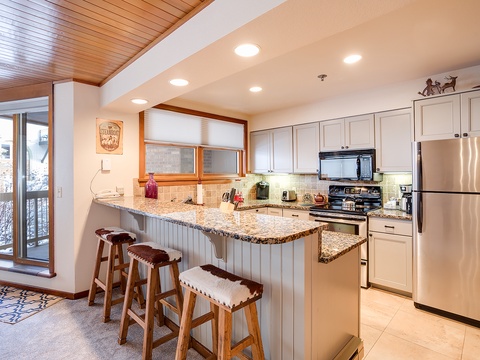 Your fully equipped kitchen awaits with granite countertops, stainless appliances, and a spacious breakfast bar perfect for morning coffee or meal prep after a day on the slopes.