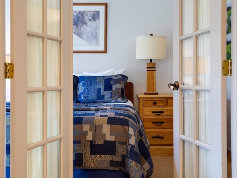 Step into your cozy retreat where a handsome blue quilt and warm wood furnishings invite you to unwind after a day of adventure. Natural light and artistic touches create your perfect home away from home.