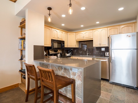Your fully equipped kitchen awaits, complete with modern appliances, ample counter space, and a breakfast bar for casual dining and morning coffee rituals.