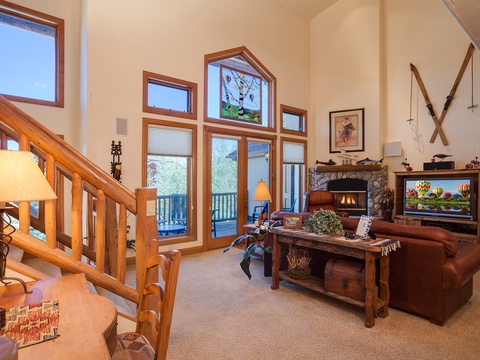 Unwind in your light-filled living space where soaring ceilings, a cozy stone fireplace, and views of the surrounding landscape create the perfect mountain retreat for relaxing evenings.