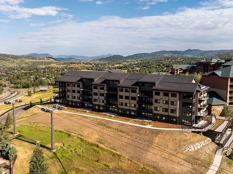 An elevated view captures the property's mountain surroundings and the neighborhood's scenic setting amid rolling hills and expansive skies.