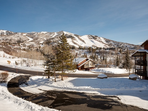 Scenic mountain property surrounded by snow-covered slopes and evergreen trees, offering easy access to winter activities and stunning alpine views.